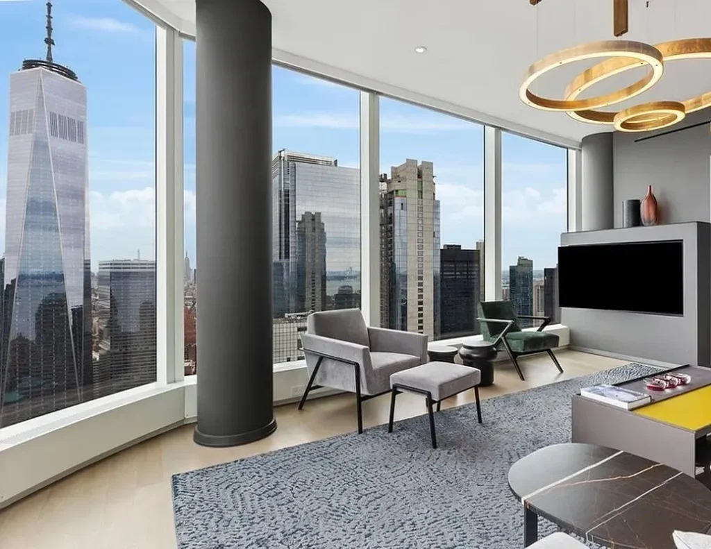 A living room with large windows and a view of the city.