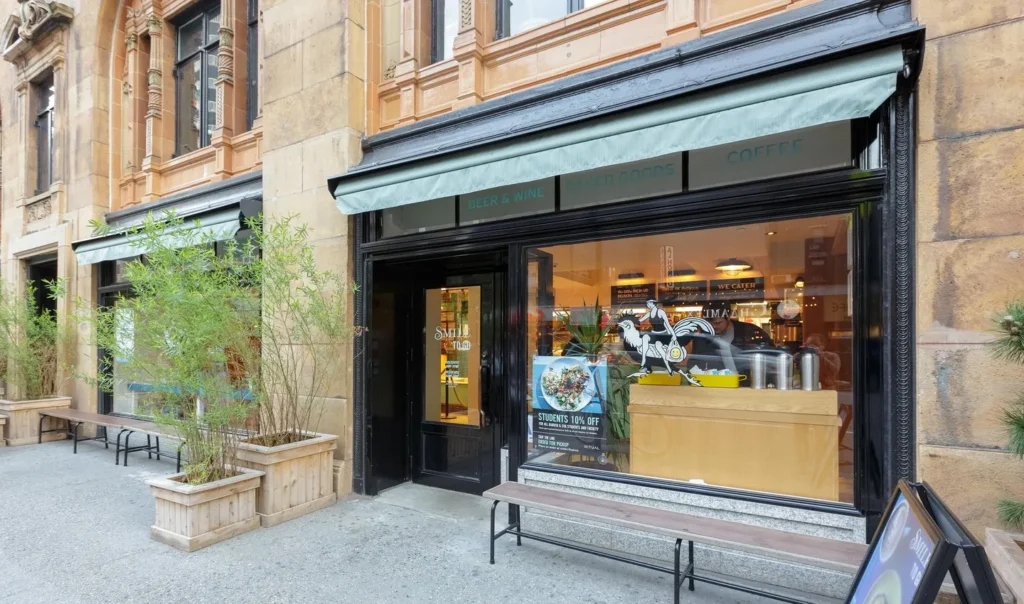 A store front with a bench outside it