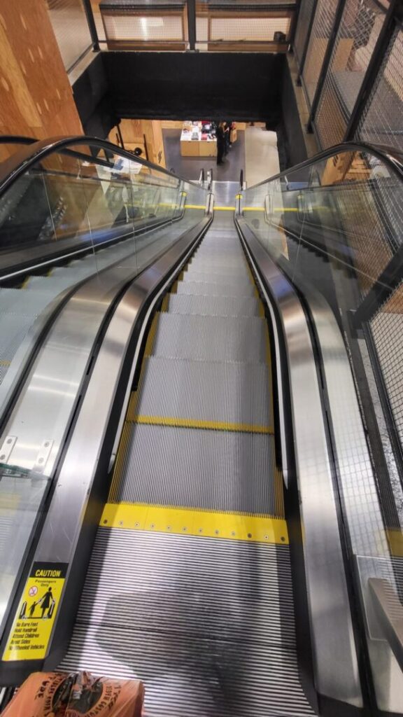 A close up of an escalator with yellow lines