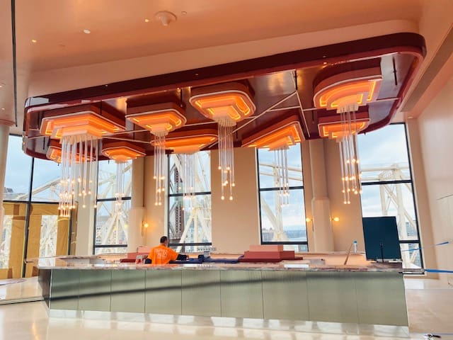 Modern indoor pool area with large windows and wooden ceiling accents.