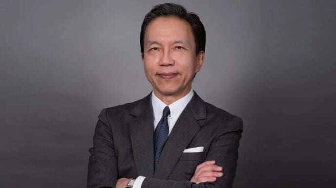 A man in a suit and tie with his arms crossed.