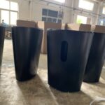 A group of black trash cans sitting on top of a floor.