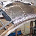 A metal structure being constructed with a sheet of aluminum foil.