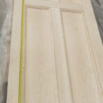 A wooden door with a measuring tape on it.