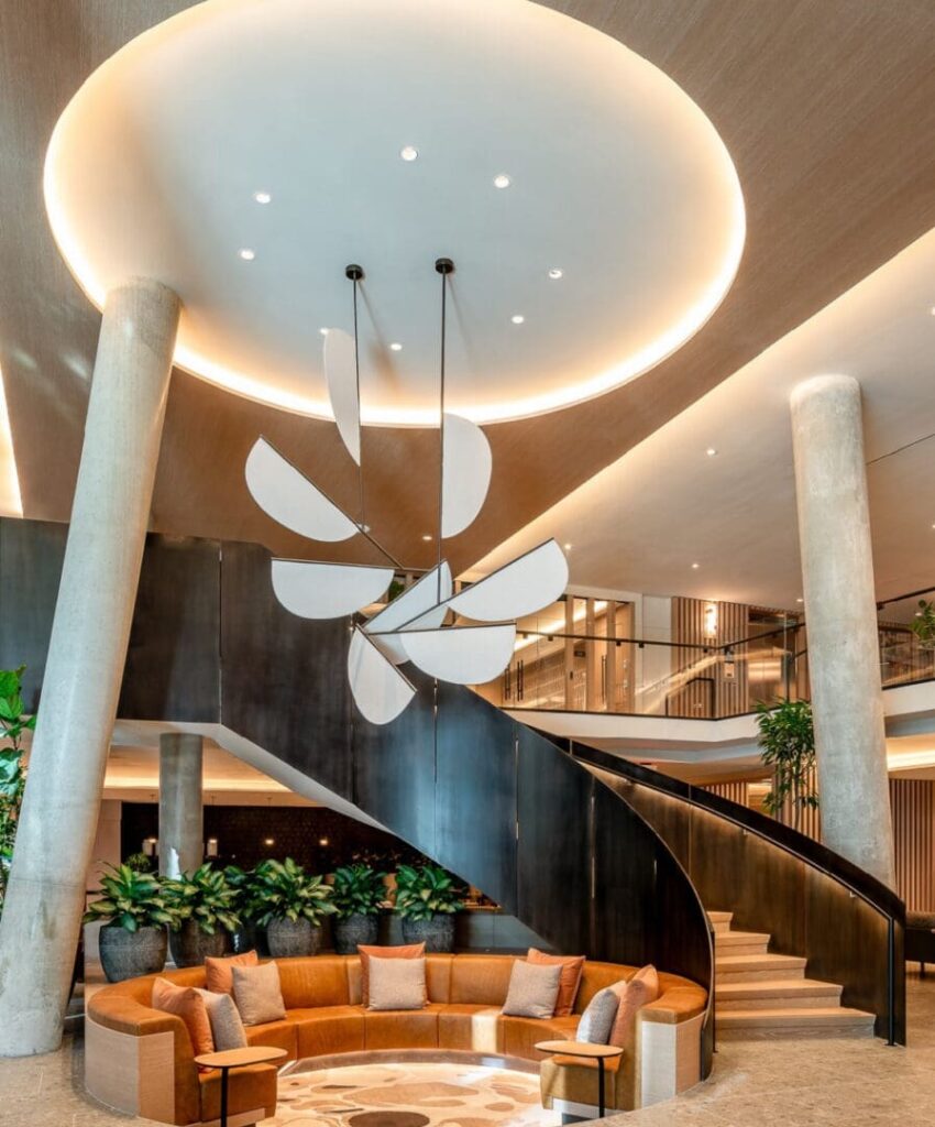 A large lobby with a spiral staircase and a round couch.