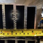 A yellow ruler is on top of some metal bars.