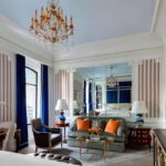 A living room with blue walls and orange accents.