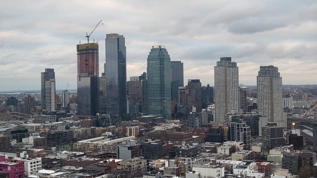 City skyline with skyscrapers under cloudy sky.