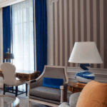 Elegant living room with classic furniture and striped wallpaper.