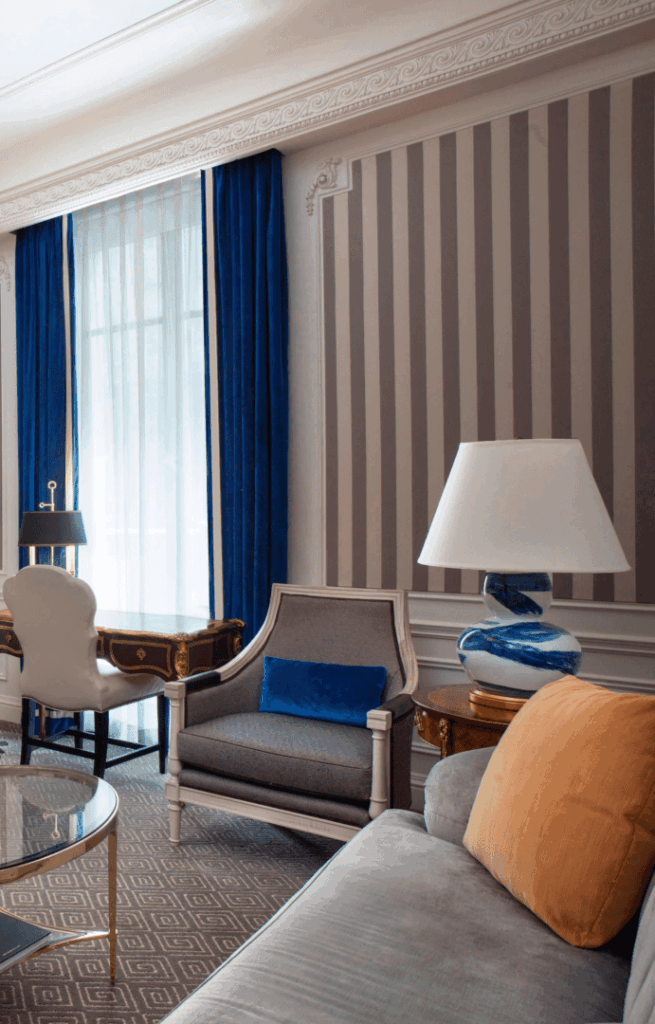 Elegant living room with classic furniture and striped wallpaper.