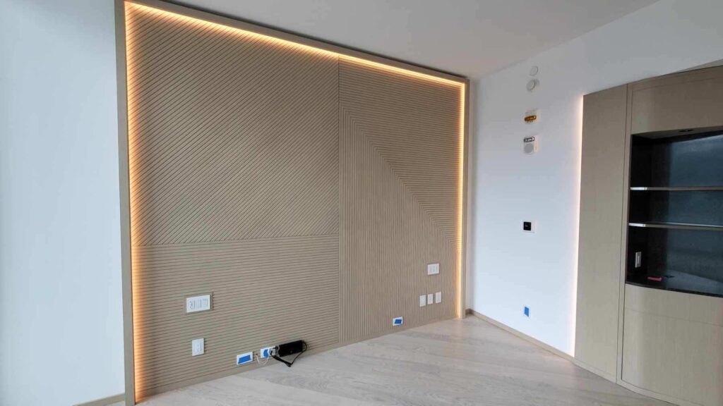 Minimalist room with wood-paneled wall and recessed lighting.