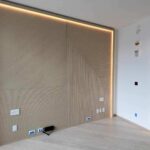 Minimalist room with wood-paneled wall and recessed lighting.