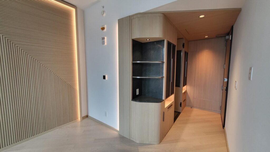 Modern living room corner with built-in shelves and soft lighting.