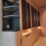 Modern wooden shelves and cabinets with LED lighting in a cozy interior.